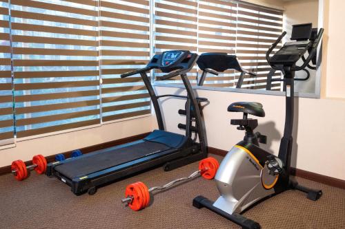 a gym with a treadmill and a exercise bike at After Hours Residence in Dhaka