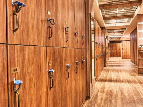 a row of wooden lockers in a hallway at Anshin Oyado Woman&Man Nagoya Sakae in Nagoya