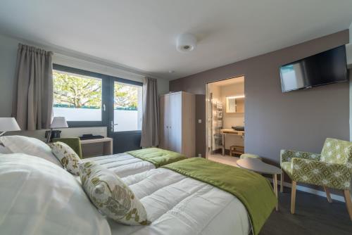 ein Schlafzimmer mit 2 Betten und ein Wohnzimmer in der Unterkunft Résidence les Dombes in Rillieux