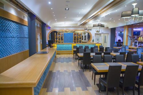 a restaurant with tables and chairs and a bar at Pantelidis Hotel & Spa in Ptolemaida