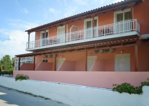 ein orangefarbenes Gebäude mit einem Balkon an der Seite in der Unterkunft XIDIS in Laganas