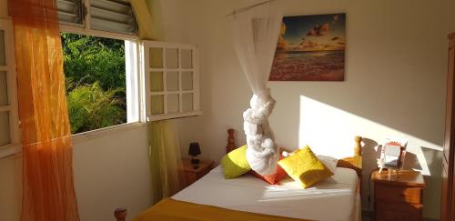 a bedroom with a bed and a window at TI-COLO in Sainte-Anne