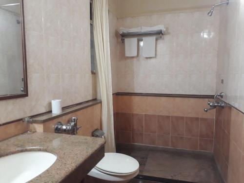 a bathroom with a toilet and a sink at The Samrat Hotel near Pune Railway Station in Pune