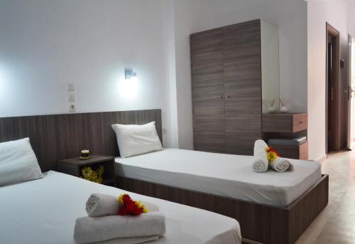 a hotel room with two beds with towels at XIDIS in Laganas