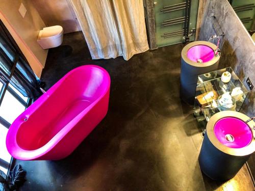 a large pink bath tub and two toilets in a bathroom at Villa Liverzano in Brisighella