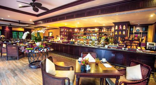a restaurant with a bar with tables and chairs at La Siesta Hoi An Resort & Spa in Hoi An