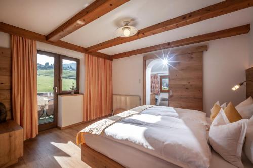 um quarto com uma cama grande e uma janela grande em Haus Margreth em Ellmau