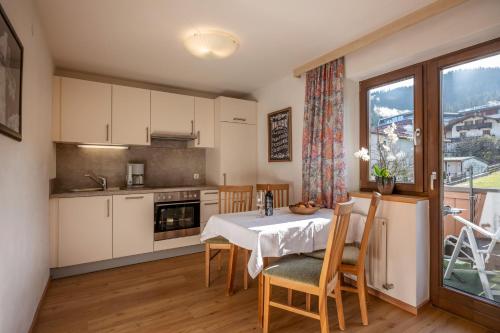 a kitchen with a table and chairs and a window at Haus Margreth in Ellmau