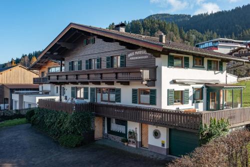 a large house with wooden balconies on a hill at Haus Margreth in Ellmau