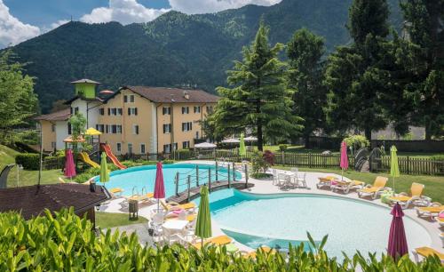 a large pool with chairs and umbrellas in a resort at Residence Ledro in Ledro