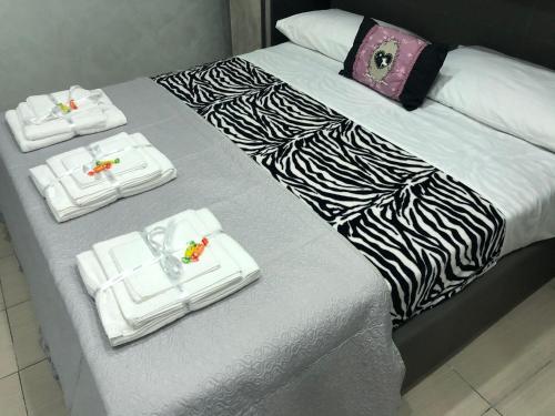 a bed with three white towels on top of it at Cuore Di Napoli in Naples