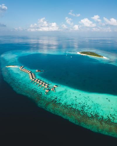 an aerial view of an island in the ocean at Angsana Velavaru In-Ocean Villas in Dhaalu Atoll