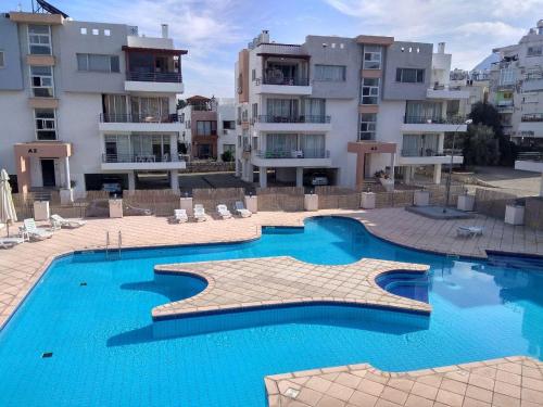 a swimming pool in front of some apartment buildings at Rix Hostel in Kyrenia