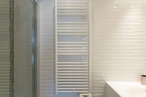 La salle de bains est pourvue de murs blancs et d'une douche avec des étagères blanches. dans l'établissement MARTINEZ HOTEL AREA: Modern 3 bedrooms w/ terrace, à Cannes