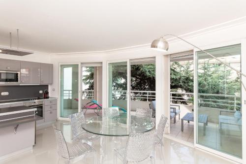 une cuisine et une salle à manger avec une table et des chaises en verre dans l'établissement MARTINEZ HOTEL AREA: Modern 3 bedrooms w/ terrace, à Cannes