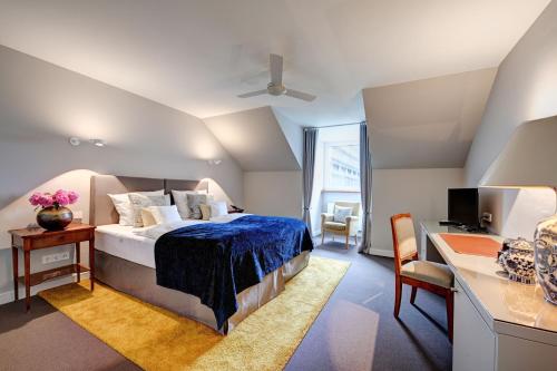 een slaapkamer met een bed en een bureau met een computer bij Hotel Admiral in München