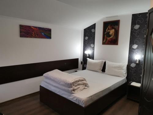 a small bedroom with a bed with white sheets at Joe Hostel in Bucharest
