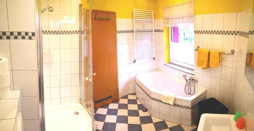 a bathroom with a tub and a shower and a sink at Havelapartments in Berlin
