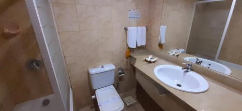 a bathroom with a sink and a toilet and a mirror at Sharm Holiday Resort in Sharm El Sheikh