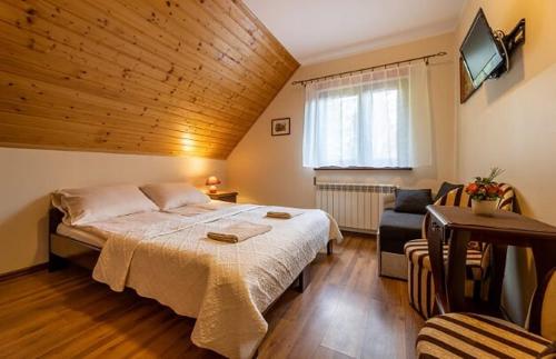 a bedroom with a large bed and a couch at Noclegi u Kiesza in Ustrzyki Dolne