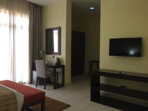 a hotel room with a bed and a table and a television at AMOR Hotel Ekiti in Ado Ekiti