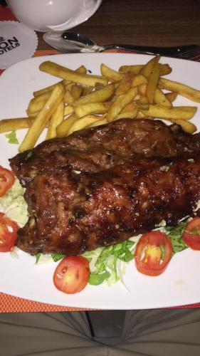 a plate of food with french fries and steak at AMOR Hotels Ekiti in Ado Ekiti