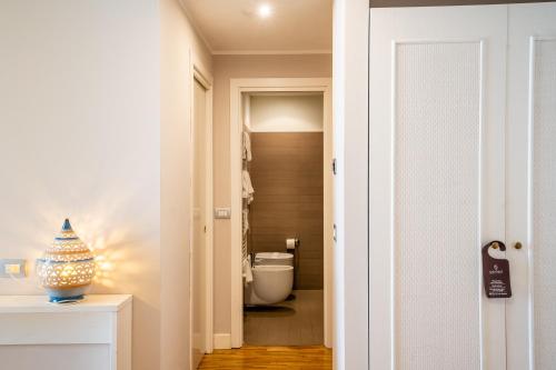 a hallway with a bathroom with a toilet in it at Capo Peloro Hotel in Torre Faro
