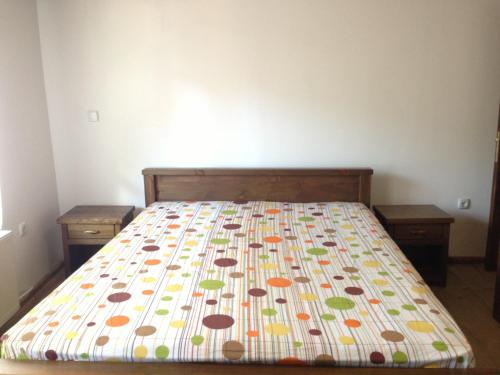 1 dormitorio con 1 cama con colcha colorida en Ristevata Guest House, en Kovačevica