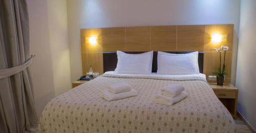 a hotel room with a bed with towels on it at Pantelidis Hotel & Spa in Ptolemaida