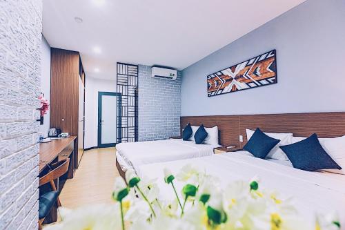 a hotel room with two beds and flowers at The G.Hotel Hue in Hue