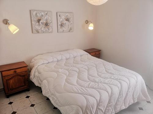 a bed in a bedroom with two pictures on the wall at VV Dúplex Los Cancajos "by henrypole home" in Los Cancajos
