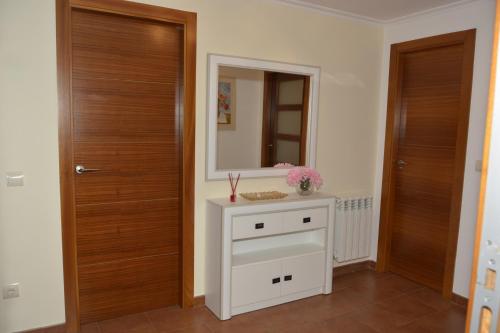 y baño con lavabo blanco y espejo. en EXCLUSIVO APARTAMENTO CON VISTAS ESPECTACULARES, en Baiona