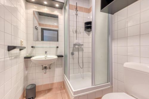 a bathroom with a shower and a sink at Hôtel Mosa in Hermalle-sous-Argenteau