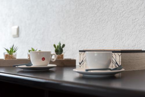 two cups of coffee sitting on a table at Hôtel Mosa in Hermalle-sous-Argenteau