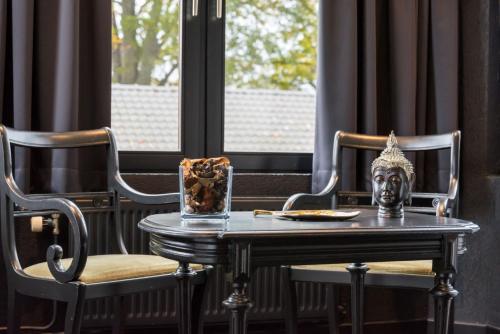 a table with a mask on top of it next to two chairs at Hôtel Mosa in Hermalle-sous-Argenteau