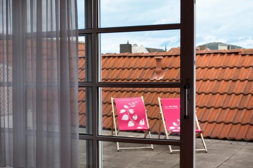 two pink chairs sitting outside a window at Altstadthotel Arte in Fulda