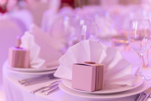 a table with white plates and napkins and wine glasses at Resident City Hotel in Almaty