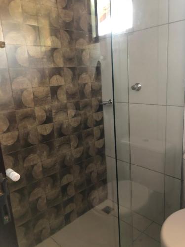 a bathroom with a shower with a glass door at Casa temporada centro capitolio MG in Capitólio