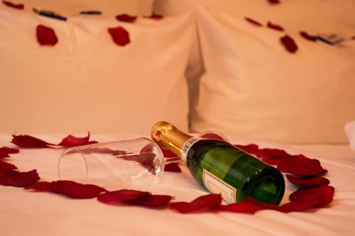 a bottle of wine laying on a bed with roses at Altstadthotel Arte in Fulda