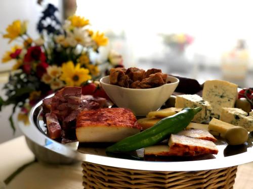 a plate of food with cheese and meat and vegetables at Pensiunea Lucia in Sfântu-Gheorghe