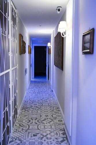 a hallway with blue walls and a tile floor at LE BERCEAU in Naples