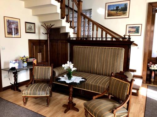 a living room with a couch and two chairs and a table at Pensiunea Lucia in Sfântu-Gheorghe