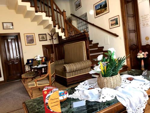 a living room with a table with flowers on it at Pensiunea Lucia in Sfântu-Gheorghe