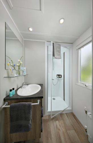 a white bathroom with a sink and a shower at KNAUS Campingpark Hennesee in Meschede
