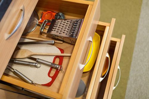 a drawer filled with kitchen utensils in a cabinet at Restaurace a penzion Pod Lipami Metylovice in Metylovice