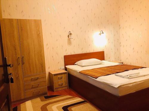 a small bedroom with a bed and a night stand at Pensiunea Lucia in Sfântu-Gheorghe