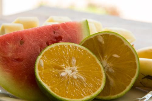 a slice of watermelon and orange slices on a plate at Villa Kiota in Paje