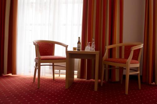 a room with two chairs and a table and a window at Altstadthotel Arte in Fulda