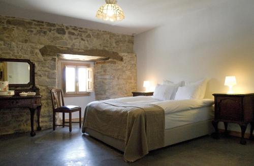 a bedroom with a bed and a table and a mirror at Hotel Rural Casa La Sonrisa in Hedeso