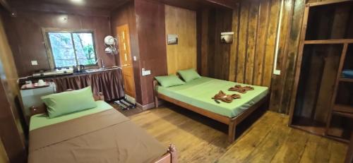 a small room with a green bed and a sink at Papa Pippo Otres Village in Sihanoukville